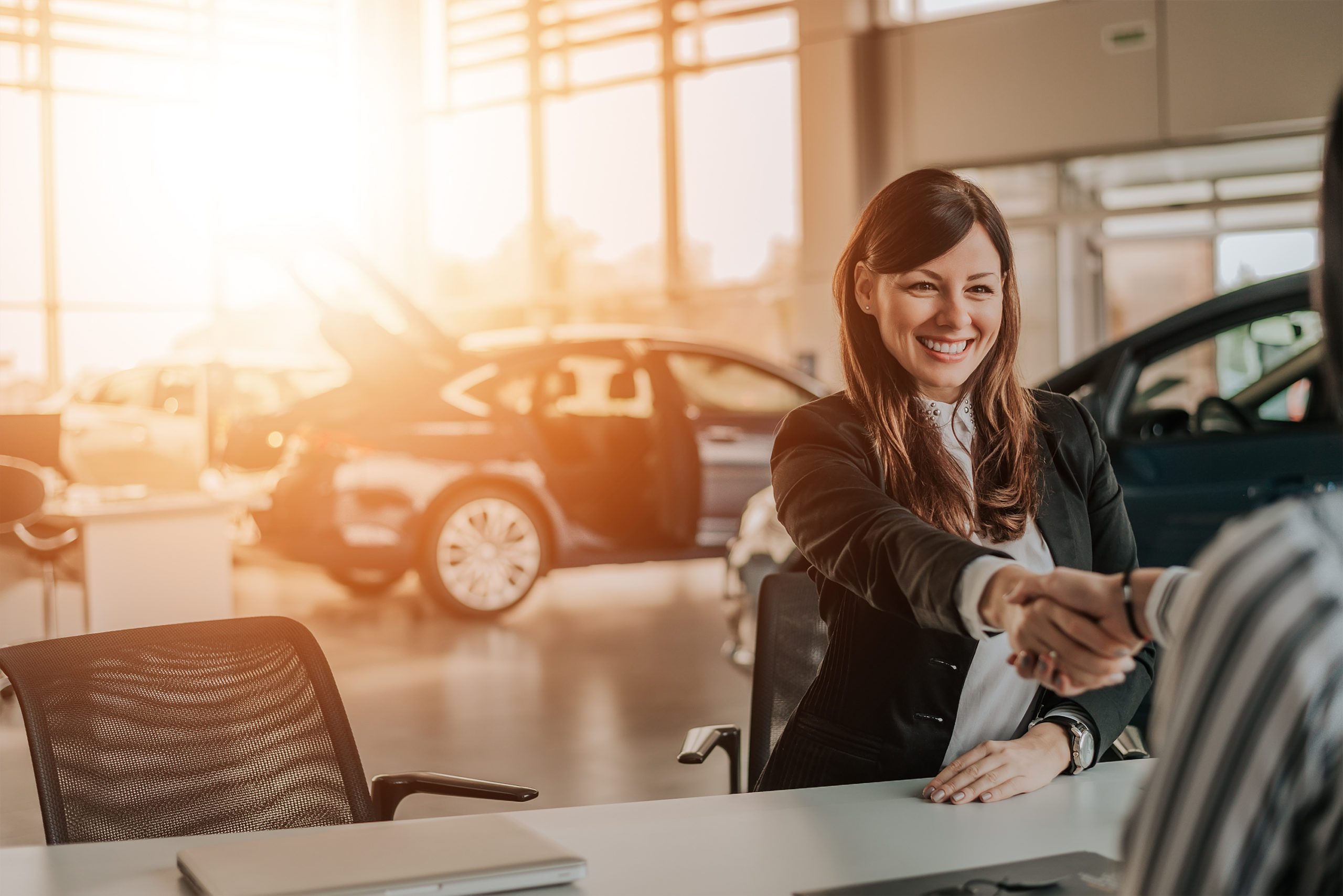 client-shaking-hands-with-car-dealer-in-showroom